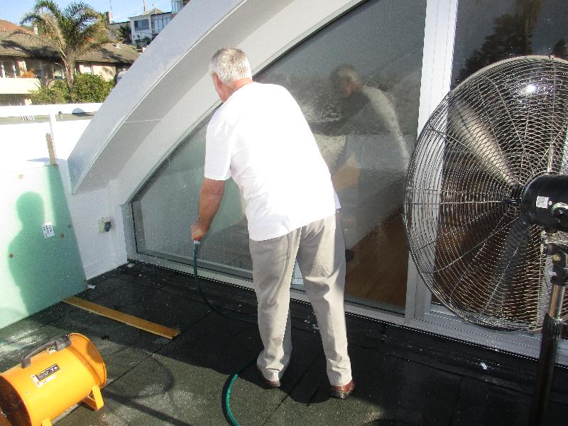 Spray testing large window units with two industrial fans